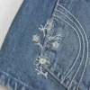Erittäin matala vyötärö, keskipitkä pesu, kukkakirjailtu denim-minishortsit Erittäin matala vyötärö, keskipitkä pesu, kukkakirjailtu denim-minishortsit