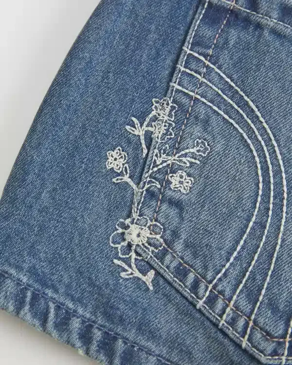 Erittäin matala vyötärö, keskipitkä pesu, kukkakirjailtu denim-minishortsit Erittäin matala vyötärö, keskipitkä pesu, kukkakirjailtu denim-minishortsit