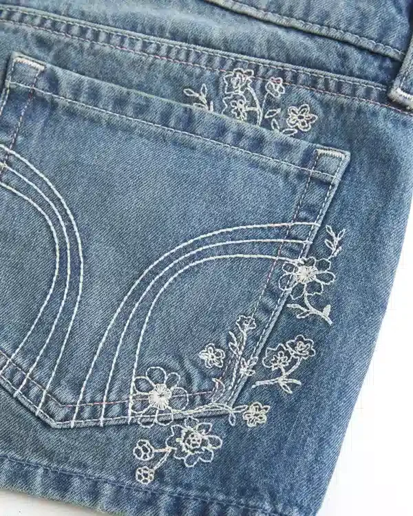 Erittäin matala vyötärö, keskipitkä pesu, kukkakirjailtu denim-minishortsit Erittäin matala vyötärö, keskipitkä pesu, kukkakirjailtu denim-minishortsit