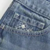 Erittäin matala vyötärö, keskipitkä pesu, kukkakirjailtu denim-minishortsit Erittäin matala vyötärö, keskipitkä pesu, kukkakirjailtu denim-minishortsit