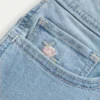Kurvikas matala vyötärö, vaalea pesu, kukka-brodeerattu denim-shortsi